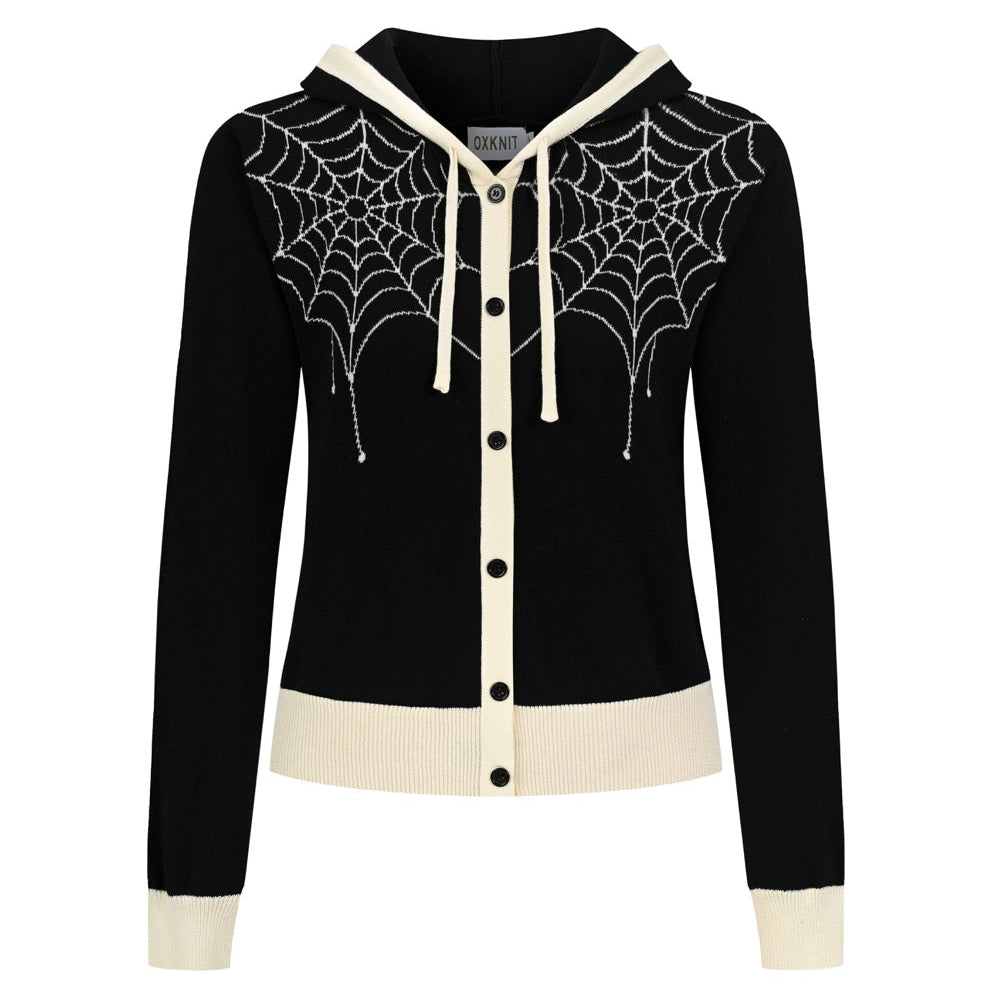 Women's black cropped hooded knit cardigan featuring cream spiderweb jacquard patterns, a button-front closure, long sleeves, and contrasting ribbed trim.